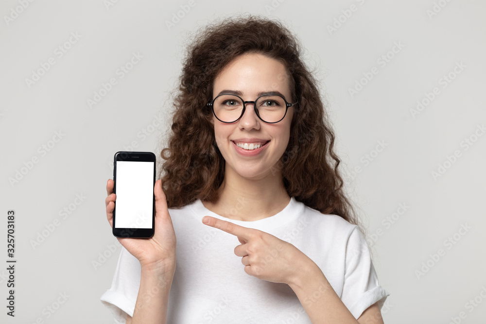 Happy smiling pretty young girl in eyeglasses demonstrating mobile screen.