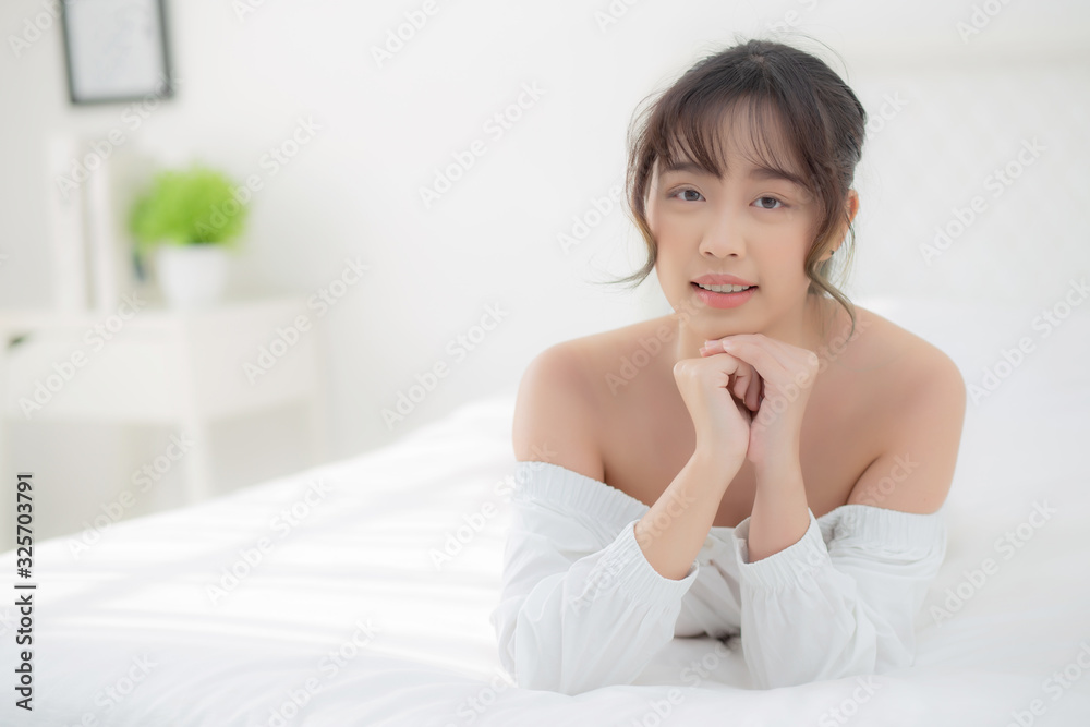 Beautiful portrait young asian woman lying and smile while wake up with sunrise at morning, beauty cute girl happy and cheerful resting on bed in the bedroom, lifestyle and relax concept. Beautiful portrait young asian woman lying and smile while wake up with sunrise at morning, beauty cute girl happy and cheerful resting on bed in the bedroom, lifestyle and relax concept.