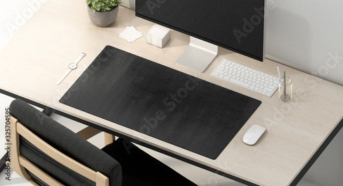 Blank black desk mat on work table mockup, top view photo