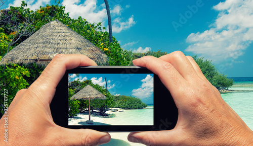 Man and woman hand capturing Maldivian Island colors with smartphone