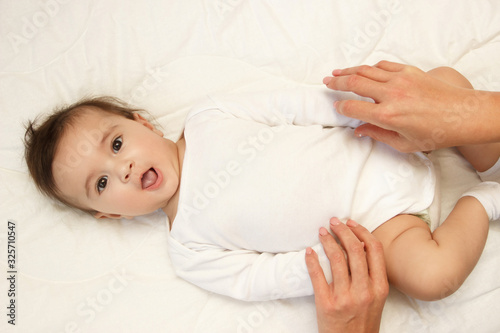 Baby and hands of mother, indoors