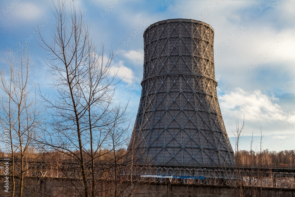 Huge metal pipe of a thermal power plant on a background of a picturesque sky