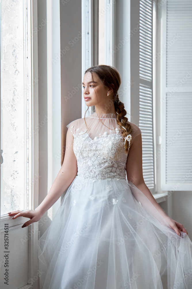 Brown-haired girl in a beautiful white wedding dress. A woman bride is waiting for the groom before the wedding Brown-haired girl in a beautiful white wedding dress. A woman bride is waiting for the groom before the wedding