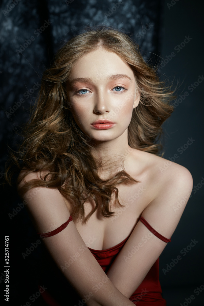 Portrait of a sexy blonde girl. Beautiful curly hair, perfect soft clean skin of a woman face. Natural cosmetics