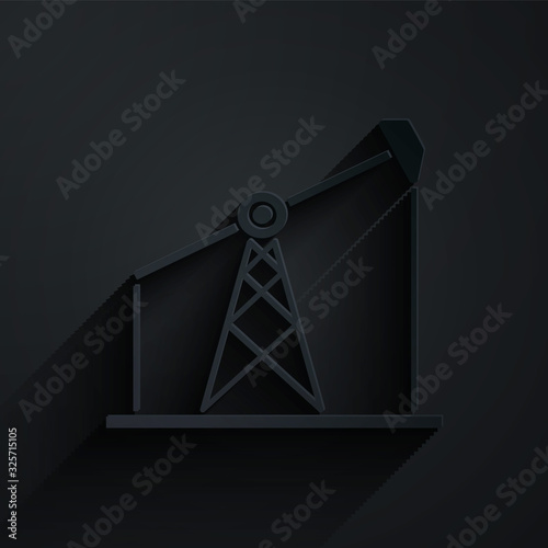 Paper cut Oil pump or pump jack icon isolated on black background. Oil rig. Paper art style. Vector Illustration