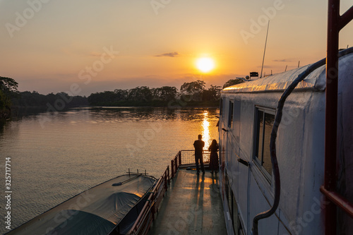 Amazon rainforest sunset during a boat trip with a reflection of the trees in the water. Puerto Francisco de Orellana. Ecuador. South America. photo