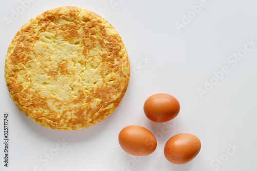 Delicious Spanish omelette with a few eggs on a white background with cpopy space photo