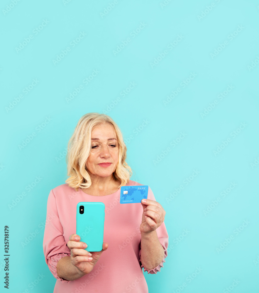 Happy woman in the pink dress holding credit card with mobile Happy woman in the pink dress holding credit card with mobile