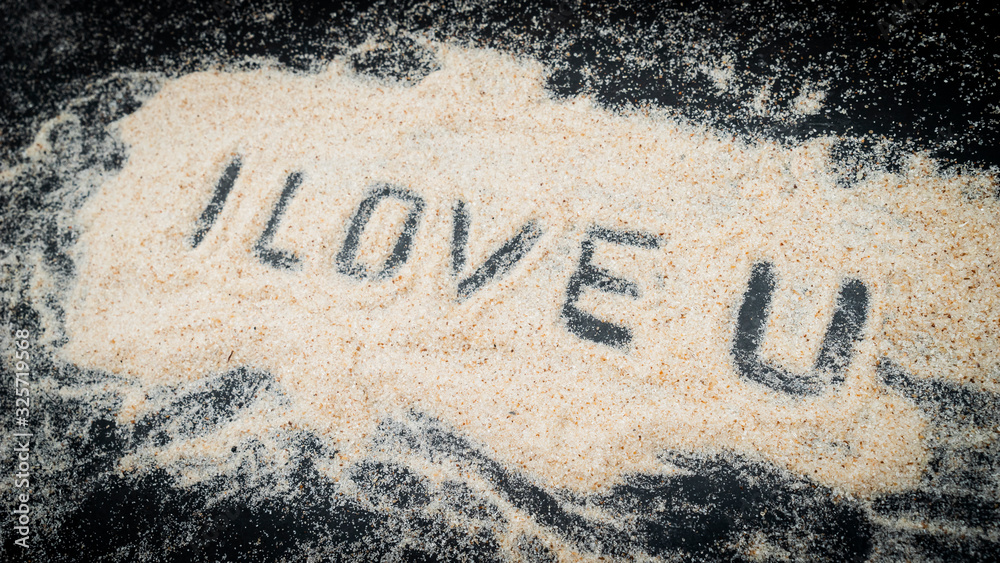 Fototapeta premium Top view of I LOVE U text written on white sand