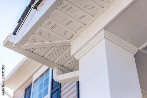 Obraz na płótnie Colonial white custom porch columns with wood looking vinyl column wrap, sheets and molding, white soffit provides optimal ventilation for roof overhangs w salonie