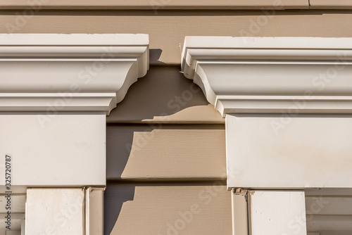 Close up of Crown molding accent above window, natural wood looking vinyl horizontal sliding