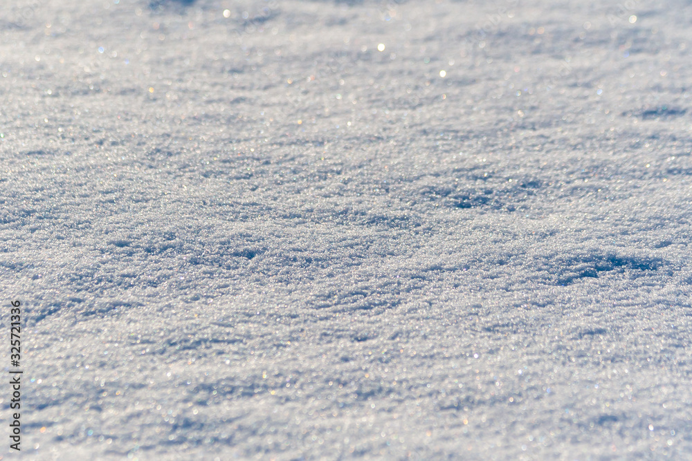 Snow cover, close-up, selective focus, shimmering with different colors.