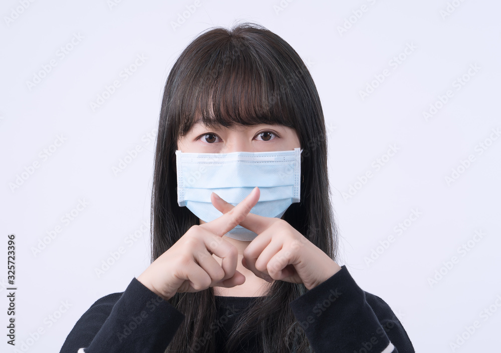 Portrait of young Asian woman, saying no to coronavirus infection with wearing medical surgical blue face mask isolated on white background, close up, closeup. Portrait of young Asian woman, saying no to coronavirus infection with wearing medical surgical blue face mask isolated on white background, close up, closeup.