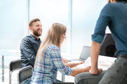 young employee discussing business documents with colleagues