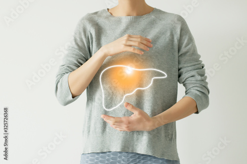 Woman in casual grey clothes suffering from indigestion pain, highlighted vector visualisation of liver photo