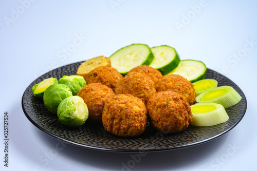 Cooking of healthy vegetarian food, tasty check pea falafels and frehs green vegetables photo