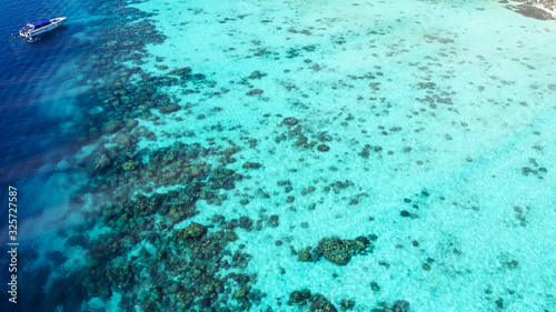 Overhead aerial view of beautiful ocean with coral reef from drone