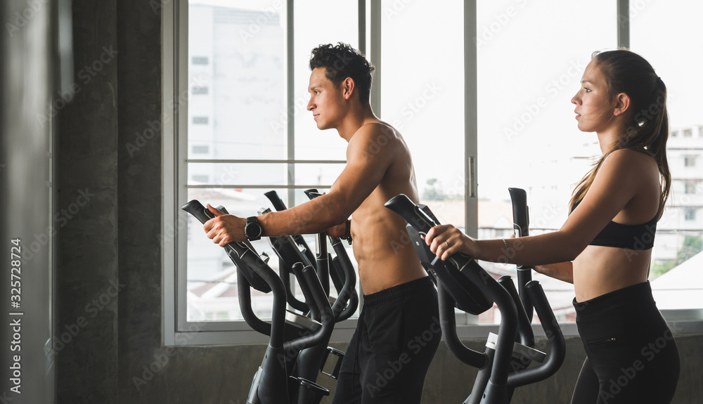Group of people at the gym exercising on the cross trainer machine. Young fitness men and women doing cardio workout program for beginner. Group of people at the gym exercising on the cross trainer machine. Young fitness men and women doing cardio workout program for beginner.