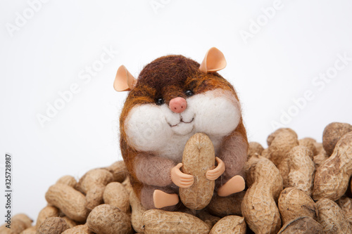 handmade artificial chipmunk with peanuts on a bunch of nuts on a white background photo