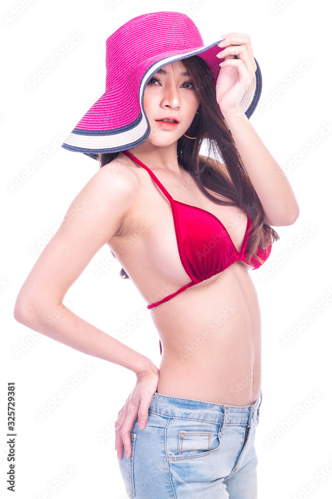 Cute asian woman in red bikini, summer hat and jeans isolated in white background. Side shot, open hat to see her face. Sexy summer concept. Cute asian woman in red bikini, summer hat and jeans isolated in white background. Side shot, open hat to see her face. Sexy summer concept.