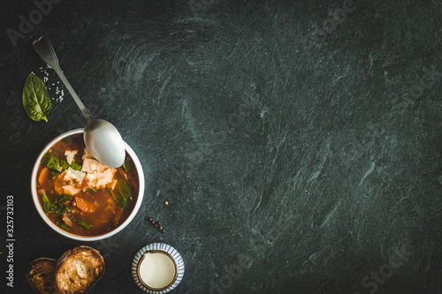 green lentil soup with tomatoes and vegetables on a dark background on the table. copy space horiizontal photo