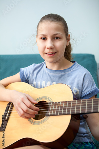 Young girl quitarist portrait with aqoustic quitar, smiling and looking at camera photo