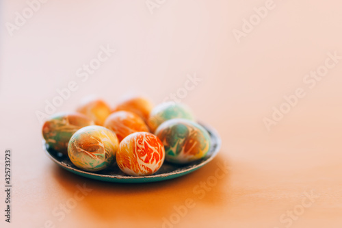 Easter eggs with ornament on green plate with napkin on yellow background