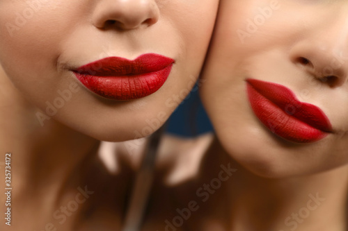 Beautiful woman with red lipstick near mirror, closeup