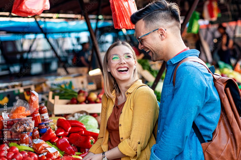 Beautiful young couple buying fresh vegetables on outdoor market. Beautiful young couple buying fresh vegetables on outdoor market.