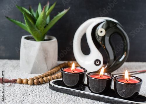 aromatherapy and feng shui concept. Aroma lamp with yin yang symbol, candles, aroma sticks, rosary and flower in a concrete pot. Buddhism, meditation, bazi, zen photo