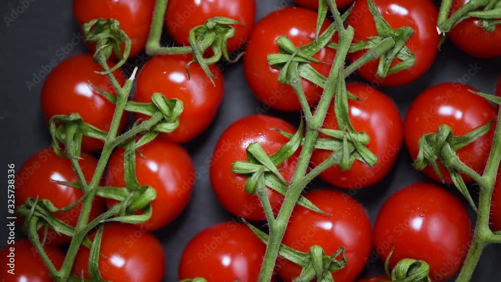 Cherry tomatoes on rotating background. Top view. Vegan and raw food concept. Bunch of fresh red tomatoes Cherry tomatoes on rotating background. Top view. Vegan and raw food concept. Bunch of fresh red tomatoes