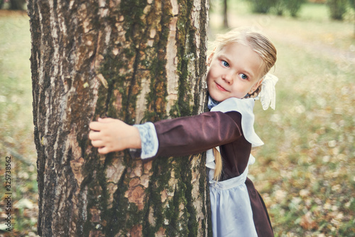 little girl hugged a tree. care concept.