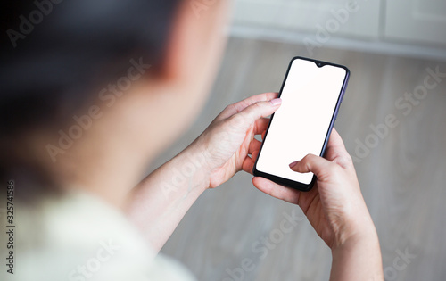 Mockup image of hand holding mobile phone with blank white screen