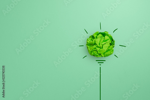 Creative idea, Inspiration, New idea and Innovation with Corporate Social Responsibility (CSR) concept, Green crumpled paper light bulb on green background.