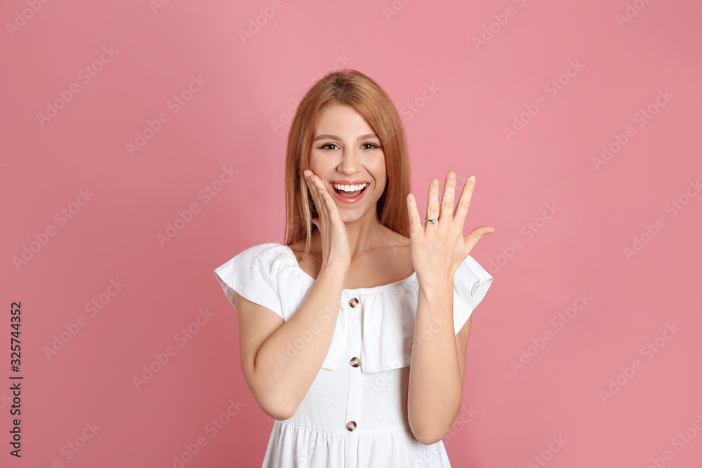 Emotional woman with engagement ring on pink background Emotional woman with engagement ring on pink background