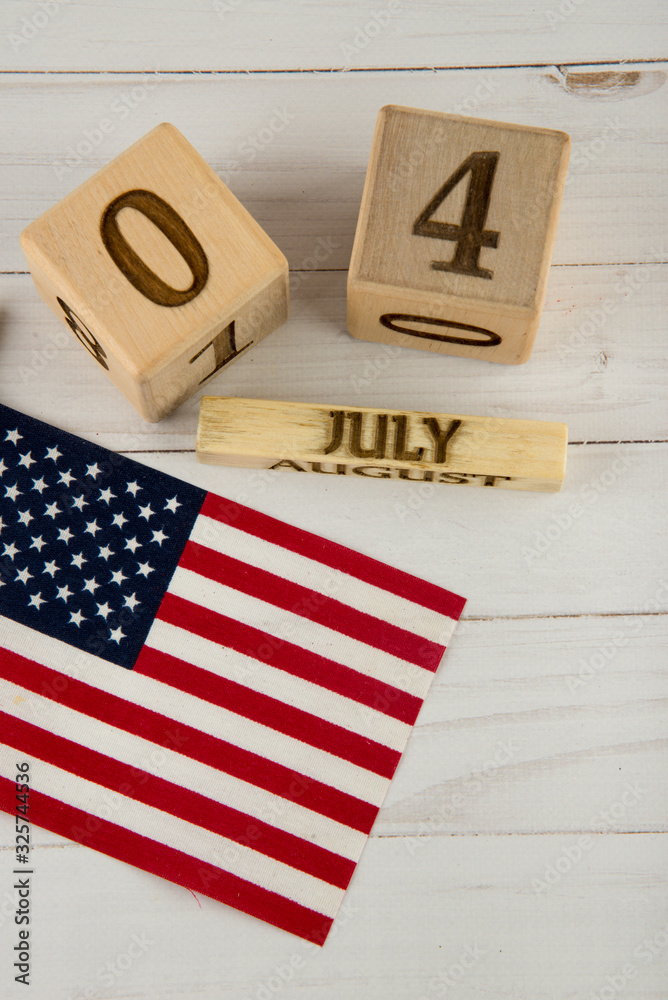 Fototapeta premium Independence day. Top view on USA flag and wooden cube calendar with 4 of July date