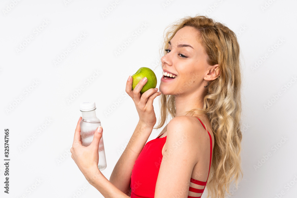 Young blonde woman isolated on white background with an apple and with a bottle of water Young blonde woman isolated on white background with an apple and with a bottle of water