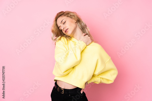 Young blonde woman wearing a sweatshirt isolated on pink background suffering from pain in shoulder for having made an effort © luismolinero