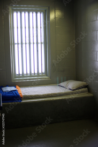 Konstfotografi prison cell interior with bed and barred window
