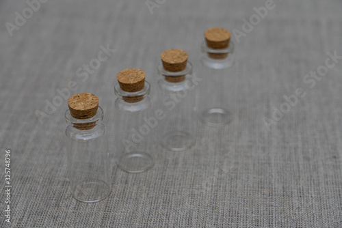 Empty small bottles vials on gray linen background photo