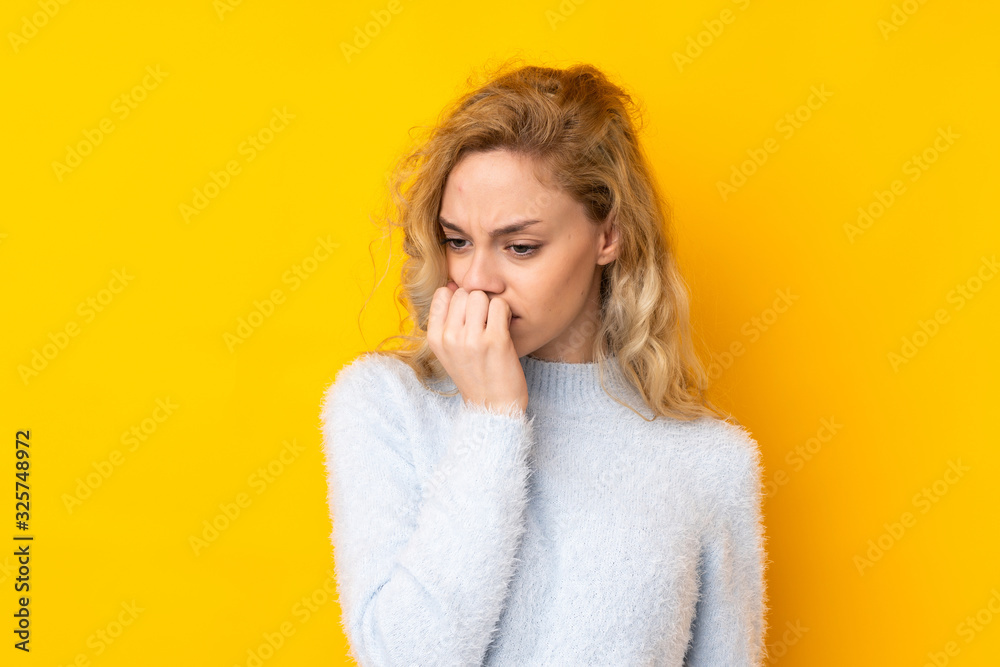 Young blonde woman isolated on yellow background having doubts Young blonde woman isolated on yellow background having doubts