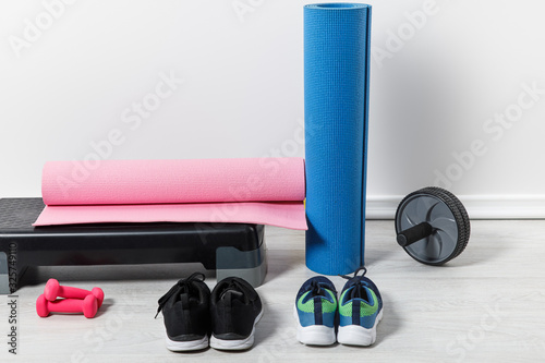 step platform, fitness mats and sportswear on floor at home
