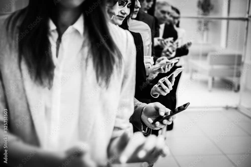 group of young business people looking at their smartphone screens