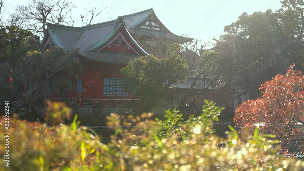 Red Japanese Temple Behind Autumn Landscape - slow motion pan shot Red Japanese Temple Behind Autumn Landscape - slow motion pan shot