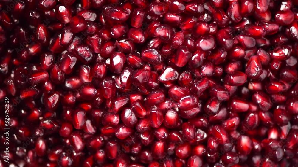 Fresh pomegranate seeds on rotating background. Top view. Green Raw organic vegetables. Vegan diet and vegetarian food concept. Fresh pomegranate seeds on rotating background. Top view. Green Raw organic vegetables. Vegan diet and vegetarian food concept.