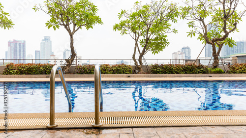 Handrails at border of swimming pool with wavy water © kowitstockphoto