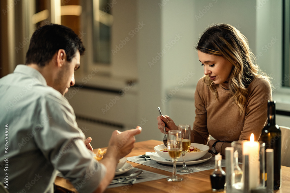 Young woman having dinner with her boyfriend in dining room.