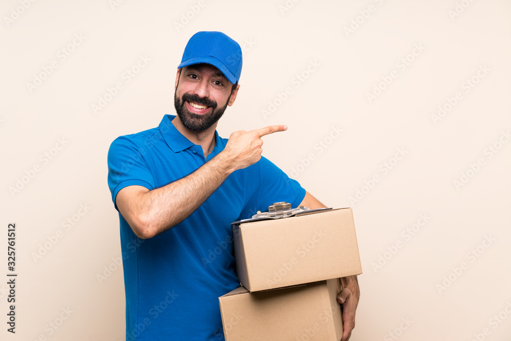 Delivery man with beard over isolated background pointing finger to the side Delivery man with beard over isolated background pointing finger to the side