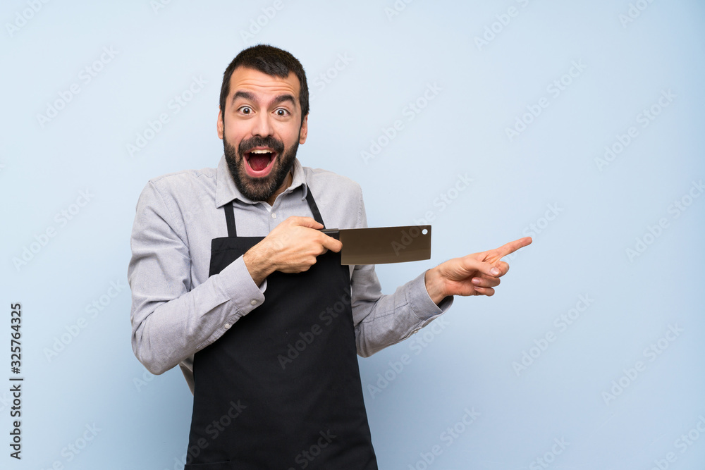 Chef over blue wall pointing to the lateral Chef over blue wall pointing to the lateral