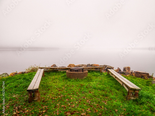 Fotografering benches and firepit by misty lake